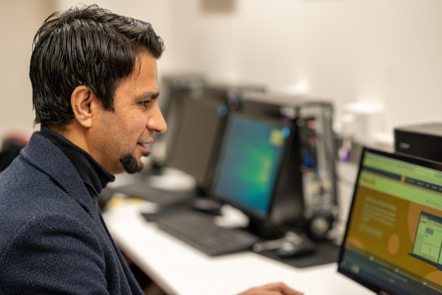 A man checks his moodle profile on a computer.